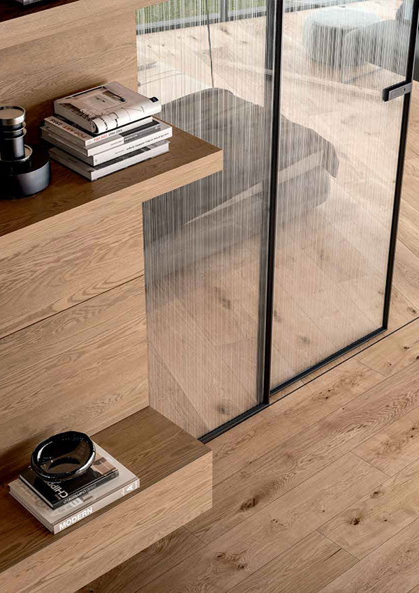 parquet in legno chiaro abbinato a porta a vetro e boiserie in legno